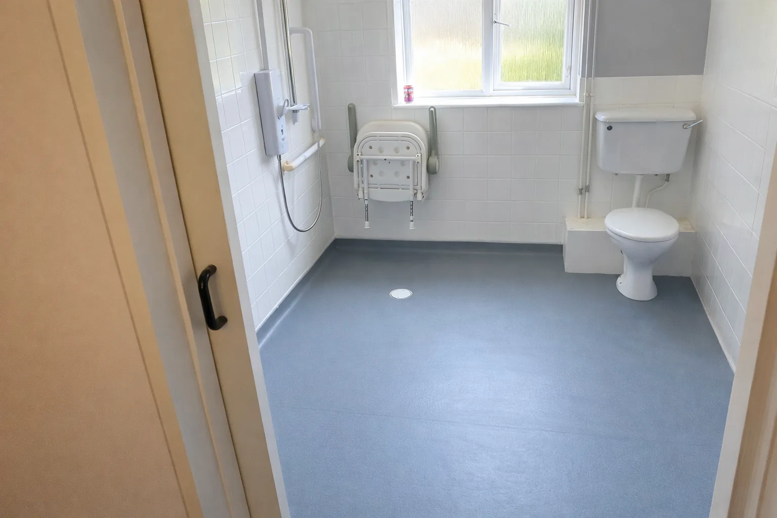 Blue wet room safety flooring installation in accessible shower room